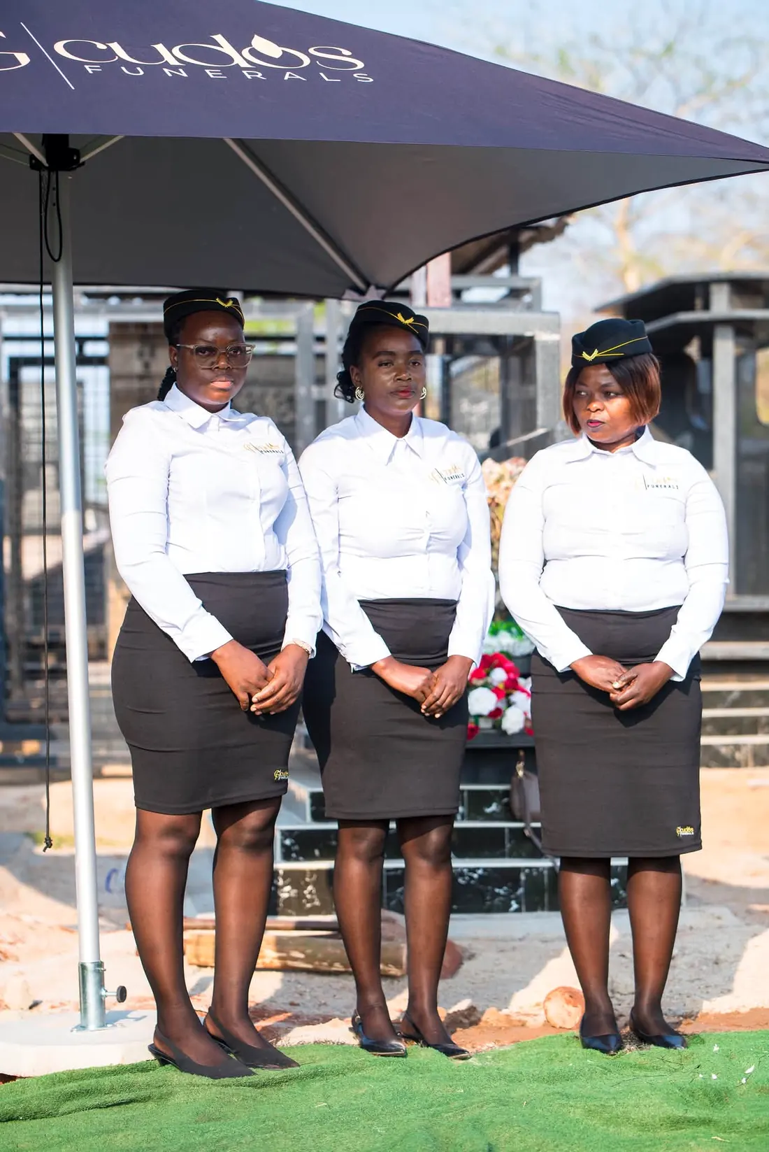 Three Cudos Funerals team members at a graveside